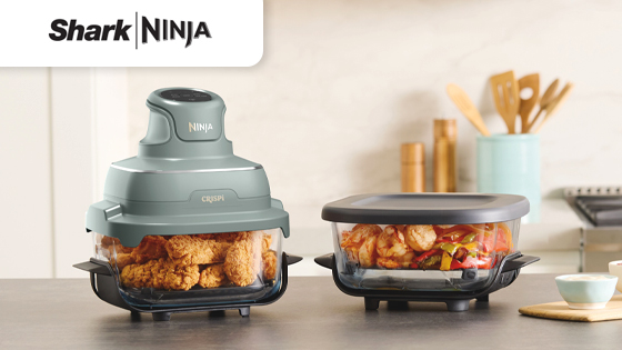 Friggitrice ad aria SharkNinja Crispi con pollo fritto e pietanza mista in contenitori da cucina moderni su piano cucina elegante