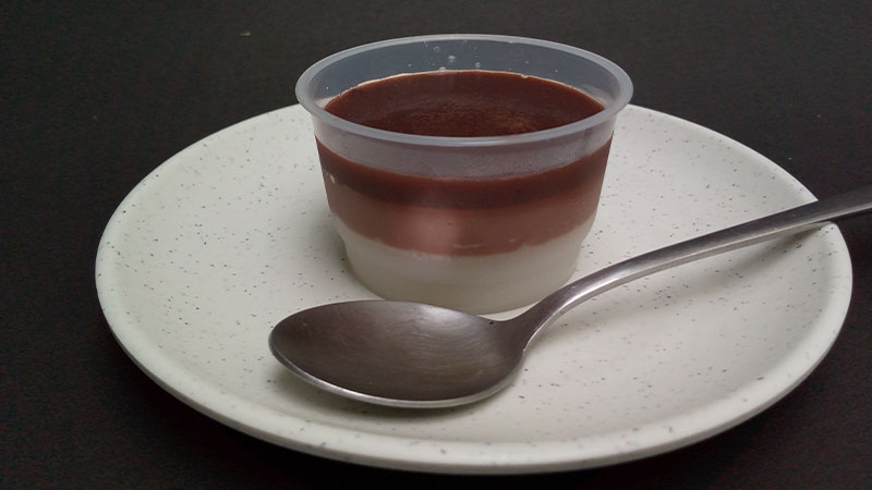 coppetta con creme e cucchiaino su piattino