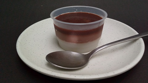 coppetta con creme e cucchiaino su piattino