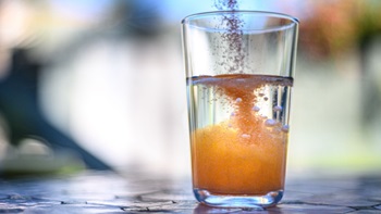 Bicchiere acqua con soluzione polverina arancione