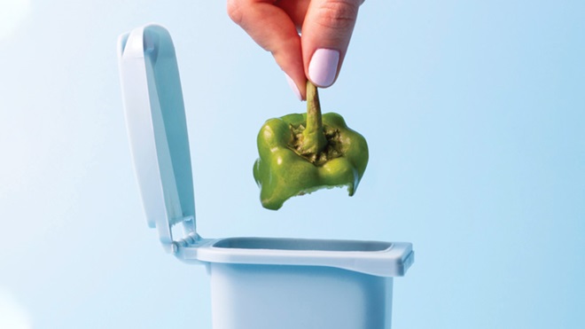 pezzo di peperone che viene buttato in pattumiera