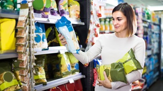 Donna sceglie le patatine da acquistare al supermercato