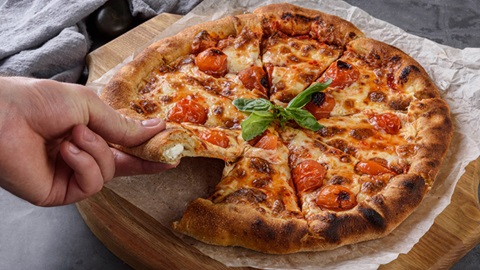mano prende fetta di pizza