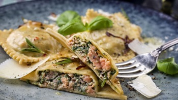 Ravioli con ripieno di pesce nel piatto con forchetta