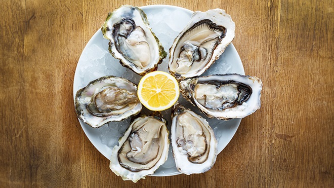 Ostriche aperte su un piatto con limone