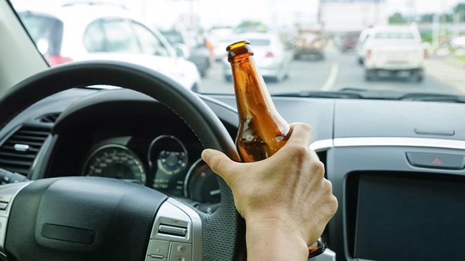 close-ip mano guidatore con bottiglia