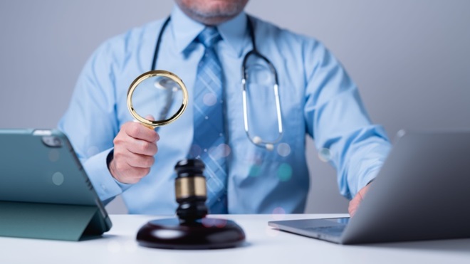 Avvocato e medico con lente in mano e computer