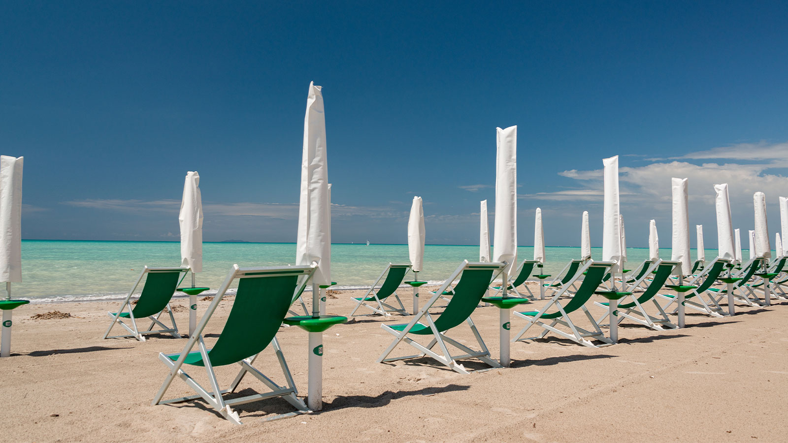 spiaggia con sdraio e ombrelloni chiusi