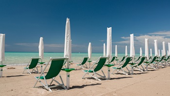 spiaggia con sdraio e ombrelloni chiusi