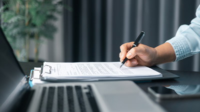 pc portatile e mano che firma