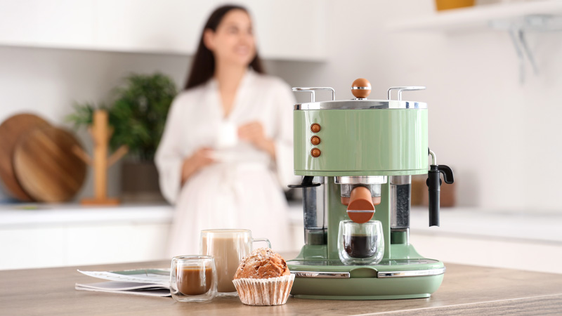 macchina per il caffè e donna sullo sfondo