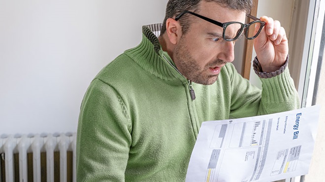 uomo legge stupito la bolletta