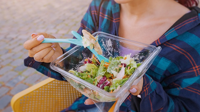 Ragazza mangia con imballaggio biodegradabile