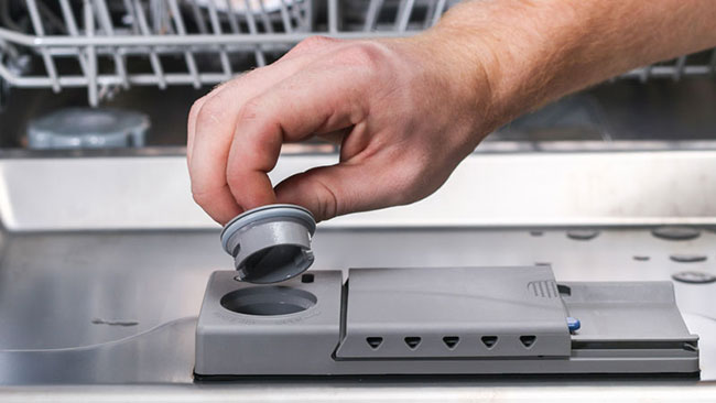 mano apre scomparto per brillantante lavastoviglie