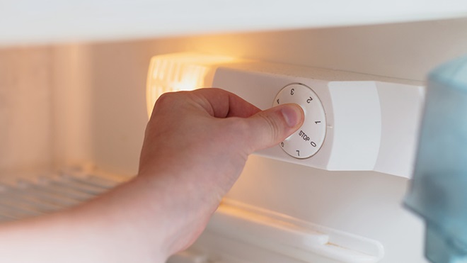 primo piano mano che imposta temperatura frigorifero