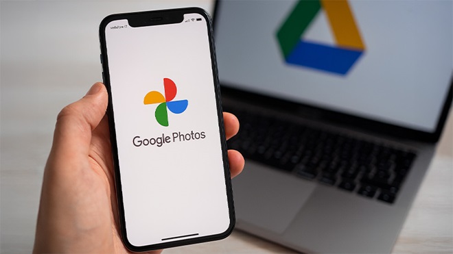 mano impugna smartphone con simbolo Google Foto