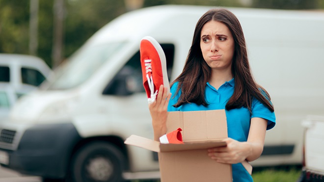Ragazza delusa con scatola e scarpe in mano