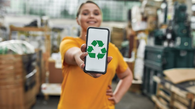 ragazza mostra smartphone con logo riciclo