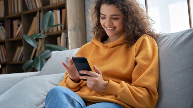 Ragazza sul divano con uno smartphone