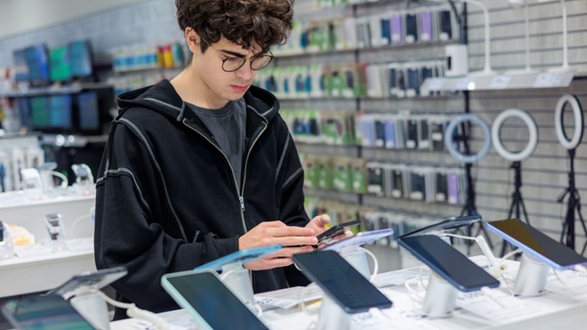 Ragazzo sceglie uno smartphone in negozio