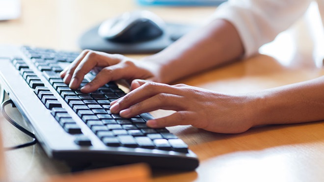 mani che utilizzano una tastiera esterna pc