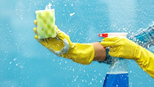 primo piano mani con guanti, spruzzono e spugna