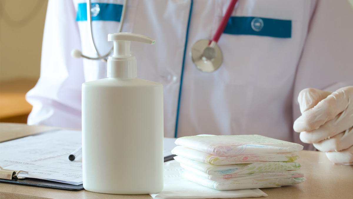 flacone su tavolo davanti e tecnico di laboratorio