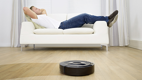 robot aspirapolvere e uomo sul divano