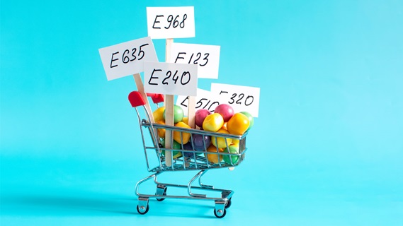 Carrello della spesa con prodotti e sigle additivi alimentari