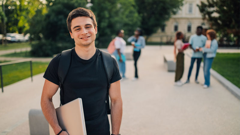 ragazzo che sorride con libro in mano