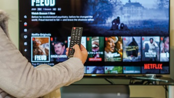 mano con telecomando daventi alla tv