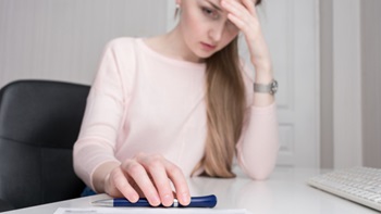 ragazza triste che guarda una penna