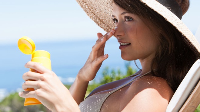 donna applicazione crema solare