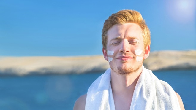Uomo al mare con crema sul viso