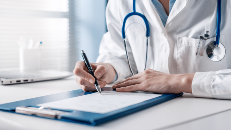 Medico che scrive un certificato