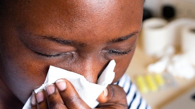 Ragazza di colore che soffia il naso