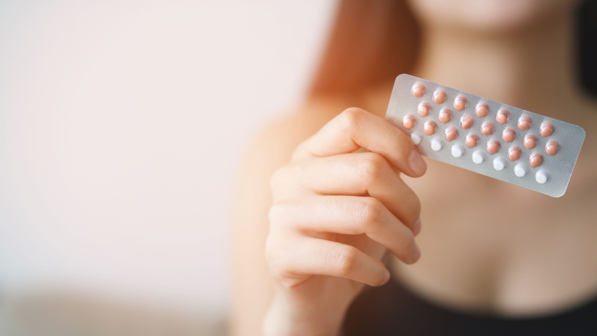Donna con in mano un blister di pillole contraccettive