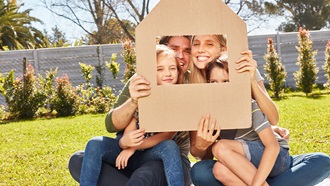 famiglia che grada attraverso un buco in un cartone