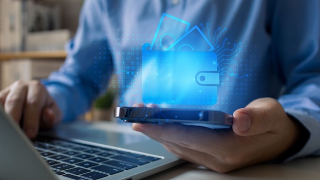 Uomo al pc con smartphone e portafoglio digitale