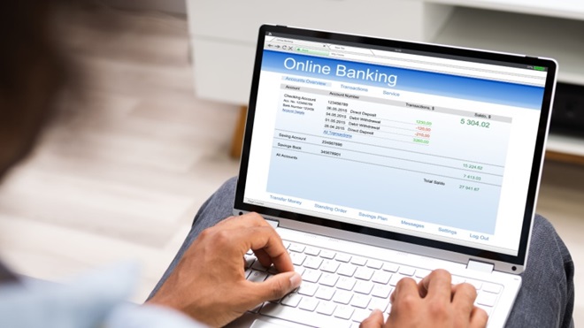 Online banking su pc e mani che scrivono