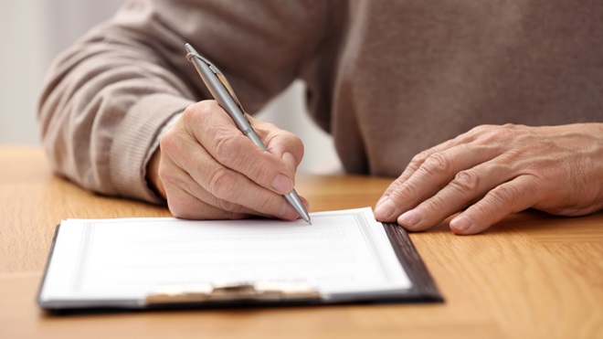 Uomo sta compilando il suo testamento olografo