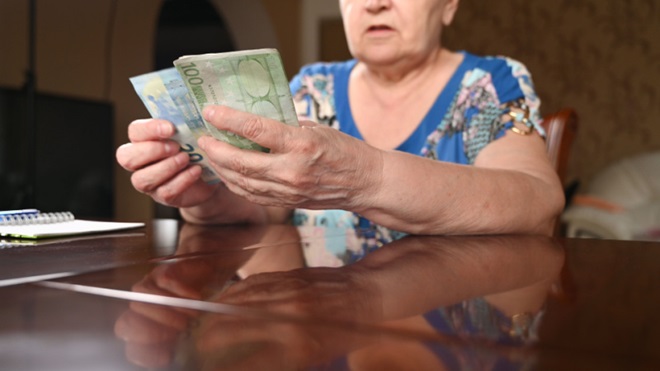 Anziana con in mano delle banconote