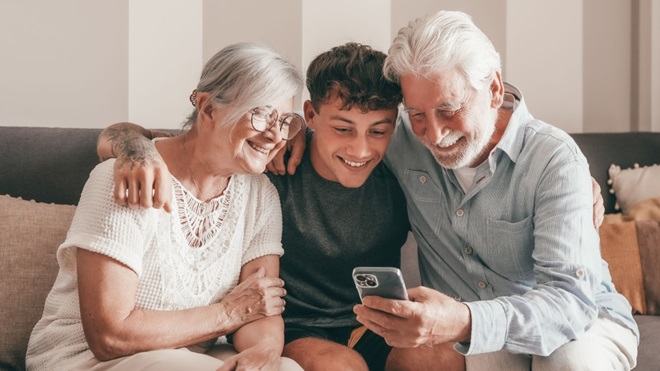 Nonni con nipote e smartphone