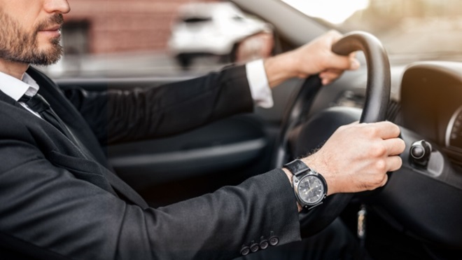Uomo in giacca e cravatta al volante