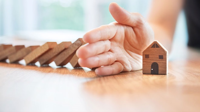 mano protegge casetta di legno