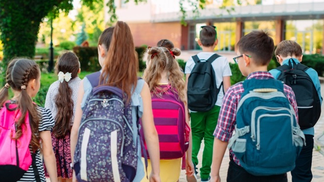 Bambini di spalle che tornano a scuola