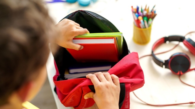 Bimbo prepara lo zaino per la scuola
