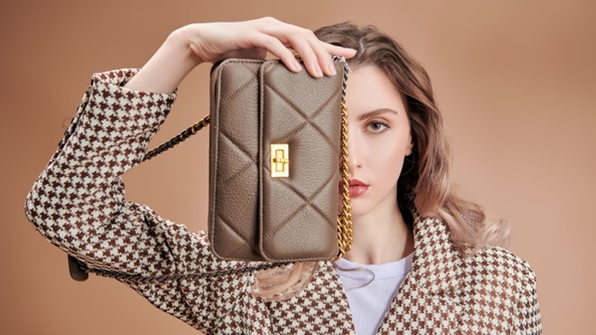 Modella con borsa davanti al viso
