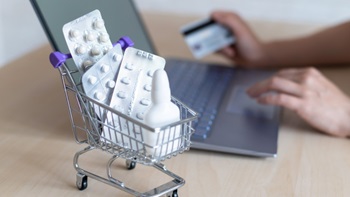 Carrello spesa con farmaci e pc con carta di credito