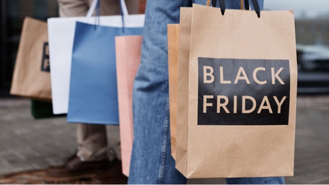 Persone con sacchetti e scritta Black Friday